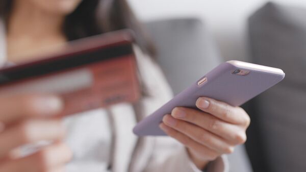 Девушка со смартфоном и банковской картой