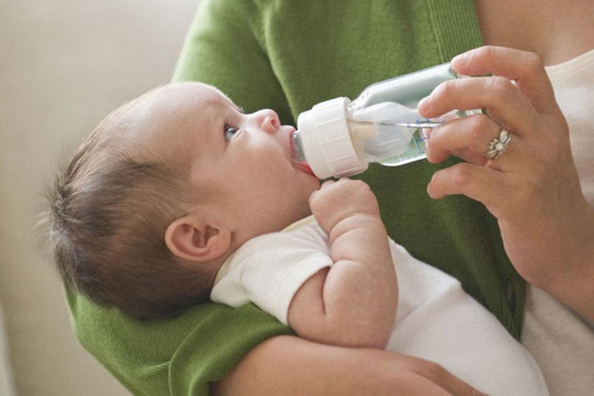 Ребенок пьет водичку из бутылочки